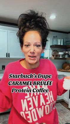 a woman in a pink shirt is holding up her hands and making a funny face with the words starbucks's drive caramel broile protein coffee