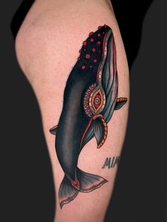 a black and red whale tattoo on the right thigh