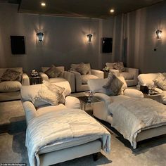 a living room filled with white couches and pillows on top of it's sides