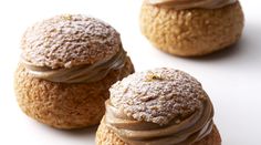 three pastries with frosting on them sitting next to each other in front of a white background