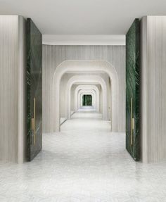 an empty hallway with marble walls and doors