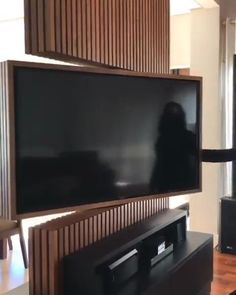 a flat screen tv sitting on top of a wooden entertainment center in a living room