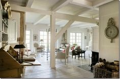 a living room filled with furniture and a clock mounted to the side of a wall