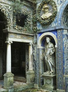 an ornately decorated building with blue and white tiles on the walls, columns and statues