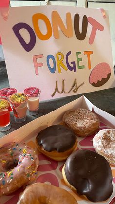 a box filled with lots of donuts next to a sign that says donut forget