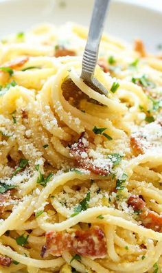 a white plate topped with pasta covered in sauce and parmesan