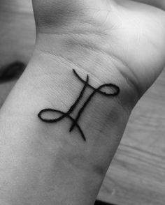 a cross tattoo on the wrist