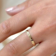 a woman's hand with a gold ring on it