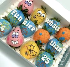 an open box filled with lots of decorated rocks and marshmallows in the shape of fruit