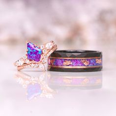 Introducing the Skye Purple Fire Opal Couples Ring Set, a stunning representation of everlasting love and commitment. This exquisite matching wedding band set combines unique design elements with high-quality materials to create a truly special symbol of your union. ►The men's ring, crafted with precision and artistry, features a hammered and brushed black tungsten carbide band. The distinctive texture adds a touch of rugged elegance, complemented by a captivating crushed opal and rose gold foil inlay. This combination of elements creates a mesmerizing play of colors and textures, symbolizing the depth and strength of your bond. ►On the other hand, the women's ring exudes feminine grace with its 14k rose gold vermeil finish. The base metal, meticulously crafted from 925 sterling silver, pr Unique Promise Rings, Lavender Opal, Couples Ring, Rose Gold Tungsten, Couples Ring Set, Purple Fire, Black Tungsten, Tungsten Wedding Bands, Wedding Goals