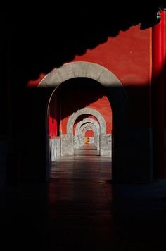 an archway in the middle of a building with red light coming from it's sides