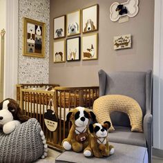 two stuffed dogs sit on the floor in front of a crib and baby's rocking chair