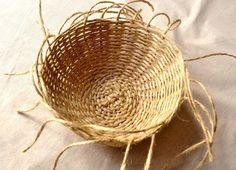 a woven basket sitting on top of a white cloth covered tablecloth with twine