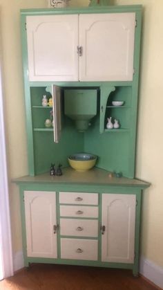 a green and white kitchen cabinet in a room