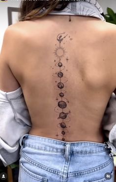 the back of a woman's neck with an image of planets and stars on it