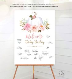 a welcome sign with pink flowers and greenery is on top of an easel