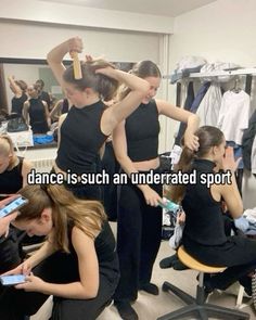 two women in black shirts and one is brushing her hair while another woman looks on