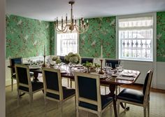 the dining room table is set with place settings for six people and has floral wallpaper