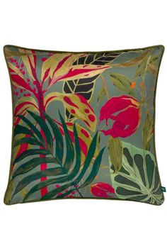 a green and red pillow with tropical leaves on the front, along with a blue background