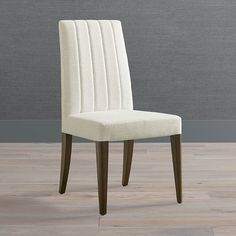 a white upholstered dining chair against a gray wall