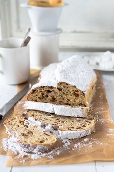 a loaf of bread sitting on top of a cutting board covered in powdered sugar