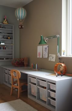 a child's room with toy storage bins and toys on the desk in front of it