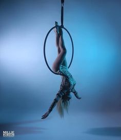 a woman is doing aerial acrobatics on a hoop