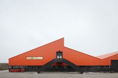 an orange building with two large triangular shaped windows