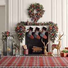 a christmas fireplace decorated with stockings and deer figurines next to a holiday wreath