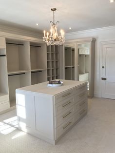 a large white kitchen island in the middle of a room with lots of closets