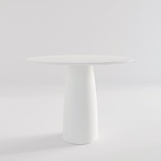 a white table with a round top on a plain surface