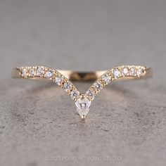 a gold wedding band with two pear shaped diamonds on top, and one diamond in the middle