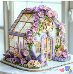 there is a cake that looks like a house with flowers on the outside and inside