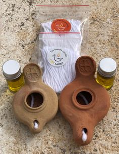 three small vases sitting on top of a counter next to some bottles and bags