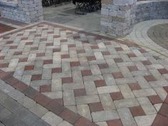 an outdoor patio with brick pavers and stone pillars