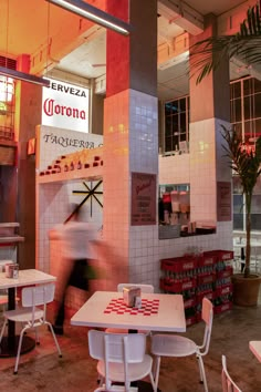 the interior of a restaurant with tables and chairs in front of a sign that says corona