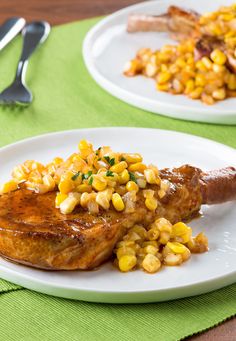 two white plates topped with meat covered in corn