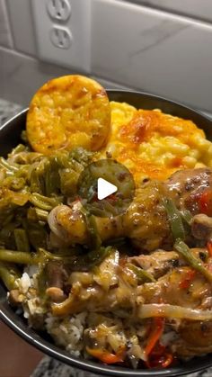 a bowl filled with rice, meat and veggies on top of a counter