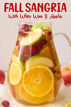 fall sangria with white wine and apples in a pitcher, garnished with cranberries