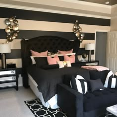 a bedroom with black and white striped walls, furniture and decor on the bed area