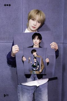 a boy holding up two pictures with his hands