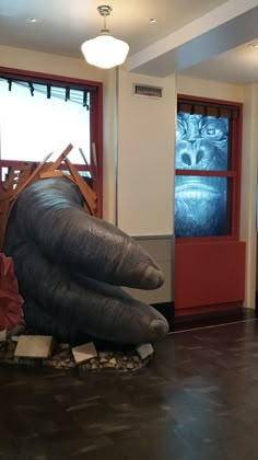 an elephant statue sitting in the middle of a room next to a red door and window