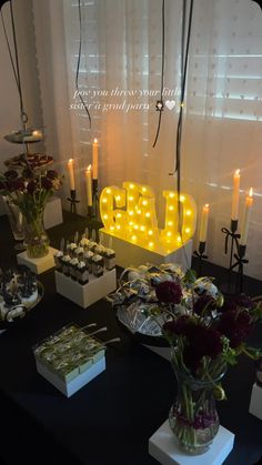 a table topped with lots of desserts and lit up letters that spell out the word love