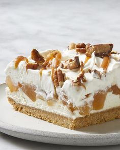 a piece of pie on a white plate with pecans and whipped cream toppings