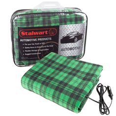 a green and black plaid blanket sitting on top of a white table next to an electronic charger