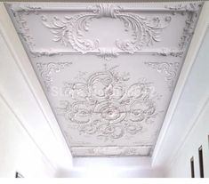 the ceiling is painted white and has ornate designs on it