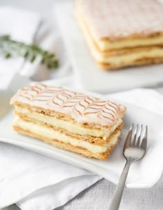 a stack of cake sitting on top of a white plate next to a knife and fork