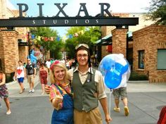 a man and woman standing under a pixar sign