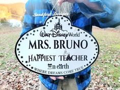 a man holding up a sign that says, mrs bruno happest teacher in earth