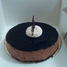 a chocolate cake with white frosting sitting on top of a table in a box